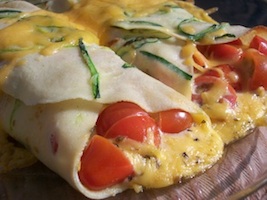 zucchini crepes filled with cherry tomatoes and cheddar cheese