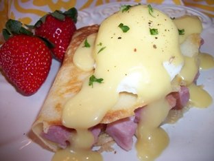 eggs benedict with hollandaise sauce over crepes