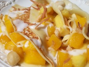 mango dessert crepes topped with creamy coconut milk sauce
